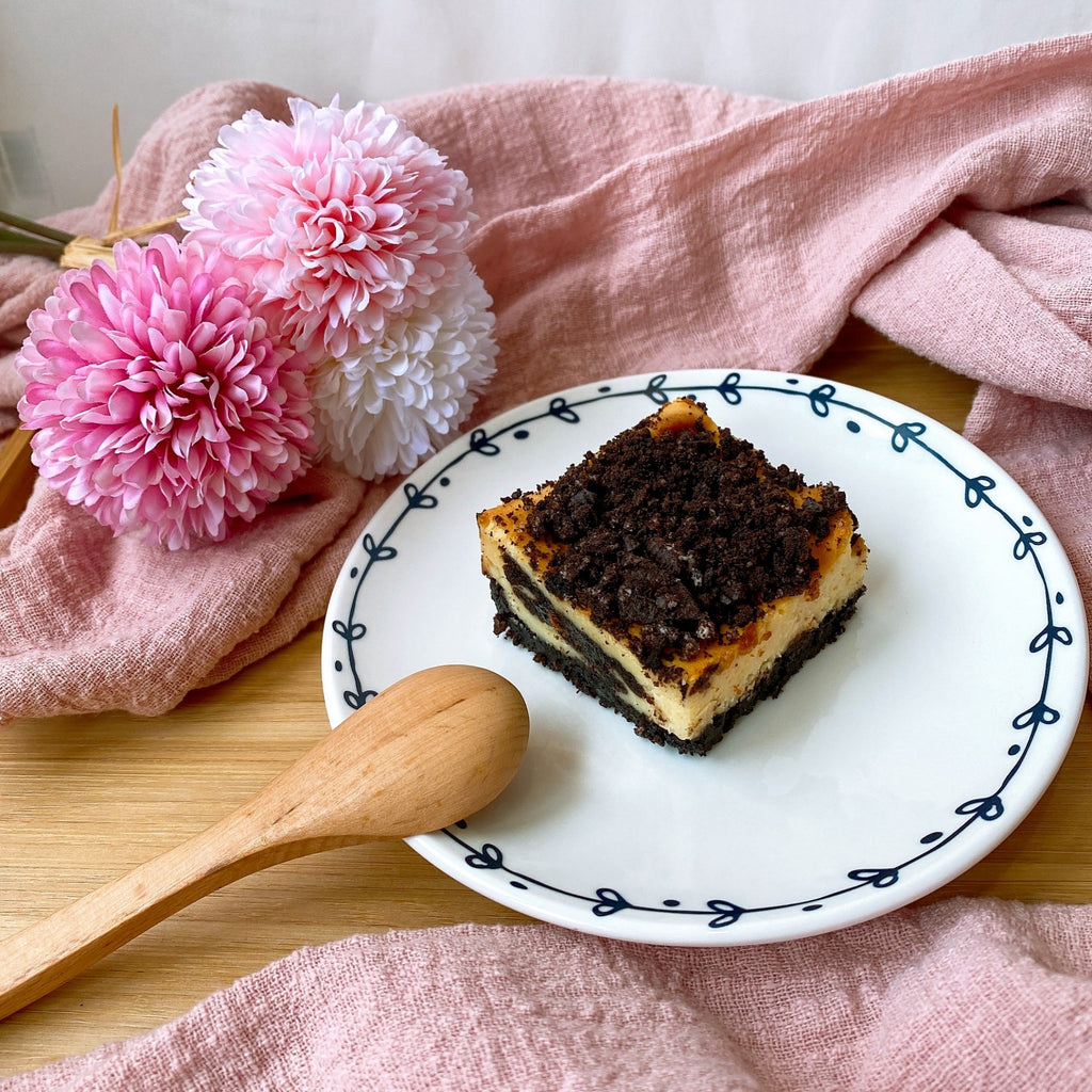 Slice of baked oreo cheesecake topped with crushed oreo bits