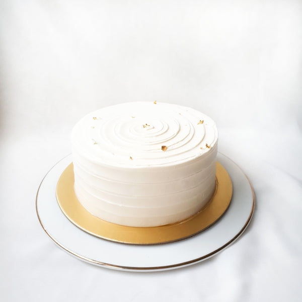 Soft vanilla sponge frosted with silky vanilla bean buttercream and topped with a gentle touch of gold leaves. 